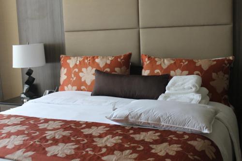 a large bed with orange and white sheets and pillows at Opera House Hotel in Bronx