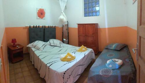 1 dormitorio con 2 camas individuales y mesa en Appt La Rose du Désert, en Terre-de-Haut