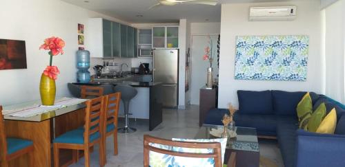 cocina y sala de estar con mesa y sofá en Aqcua Condo Vallarta, en Bucerías