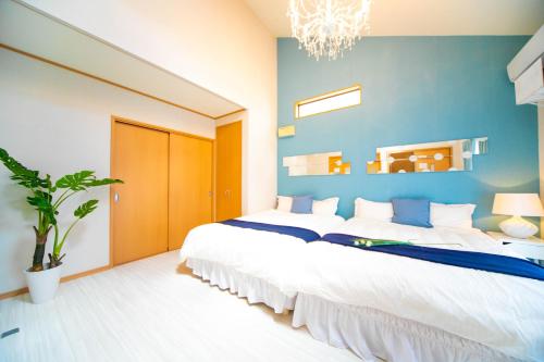 a bedroom with two beds and a blue wall at Awaji Seaside Resort Kuruma52 in Awaji