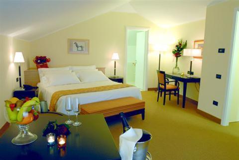クロトーネにあるPalazzo Foti Hotelのベッド、デスク(テーブルシックス付)が備わる客室です。
