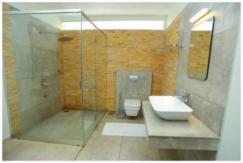 a bathroom with a shower and a sink and a toilet at Holiday Vagamon in Vagamon