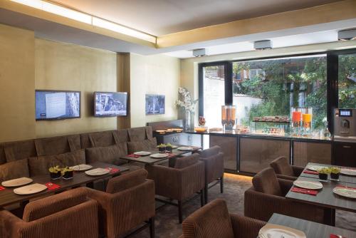 ein Restaurant mit Tischen und Stühlen und eine Bar in der Unterkunft Hotel The Neufchatel in Brüssel
