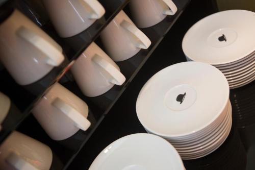 a bunch of white plates and bowls on a shelf at Hotel The Neufchatel in Brussels