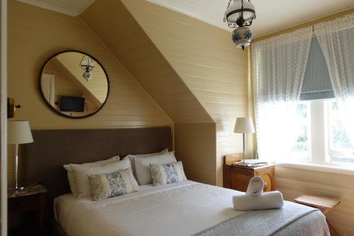 a bedroom with a large bed and a mirror at Kurrara Historic Guest House in Katoomba