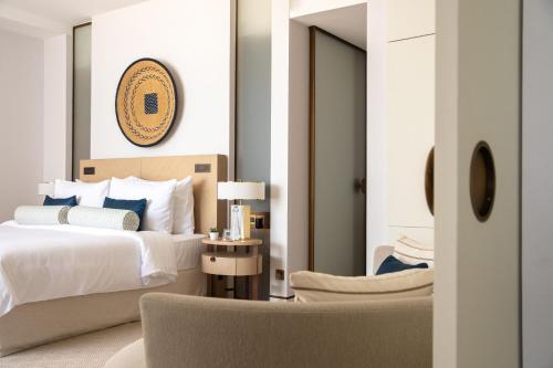 a bedroom with a bed and a chair at Jumeirah Saadiyat Island Abu Dhabi in Abu Dhabi