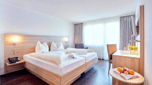 Cette chambre comprend un grand lit et un bureau. dans l'établissement Hotel Kreuz, à Leissigen