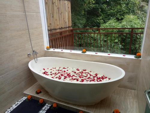a bath tub filled with flowers in a bathroom at The Pesaren Ubud in Ubud