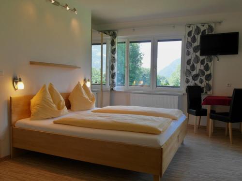- une chambre avec un lit et une grande fenêtre dans l'établissement Pension Strauß, à Ossiach