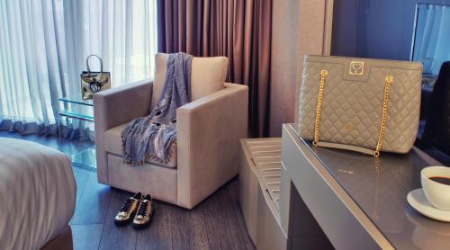 a hotel room with a chair and a table and a bed at SAZ City Life Boutique Hotel in Ioannina