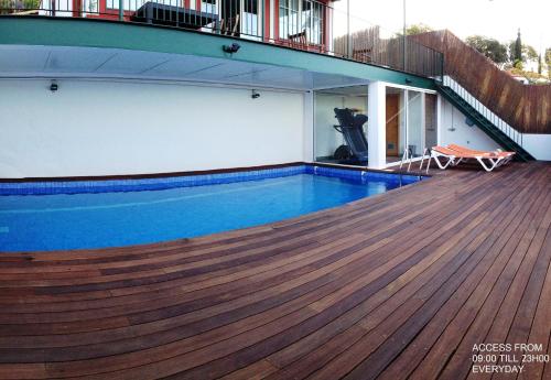 a swimming pool on a house with a wooden deck at Carvalhal Old Town in Funchal