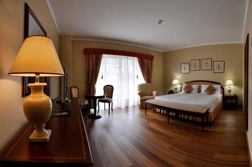 - une chambre avec un lit et une table avec une lampe dans l'établissement Hotel Talisman, à Ponta Delgada