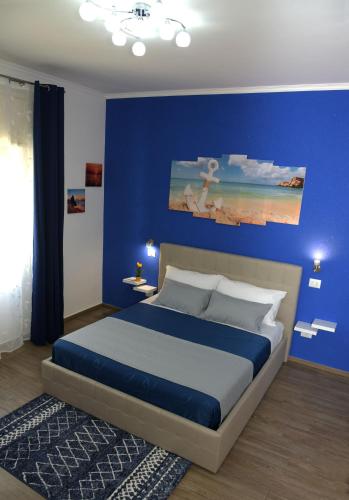a bedroom with a bed with a blue wall at B&B villa brezza marina in Sant'Isidoro