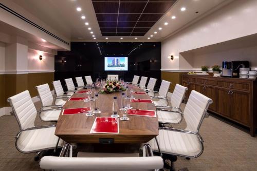 a conference room with a long table and white chairs at Ramada Jerusalem Hotel in Jerusalem