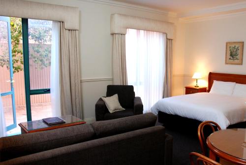 Habitación de hotel con cama y sofá en Majestic Tynte Street Apartments en Adelaida