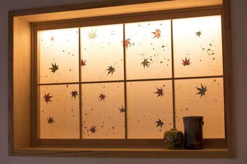 a window with spiders painted on the glass at Guesthouse Raku in Kyoto