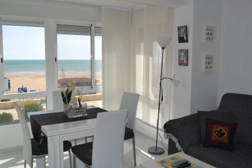 een woonkamer met een eettafel en uitzicht op het strand bij Torrenostra de LUX in Torrenostra