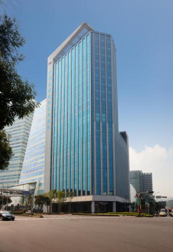 a tall glass building with a car in front of it at The Place Taipei in Taipei