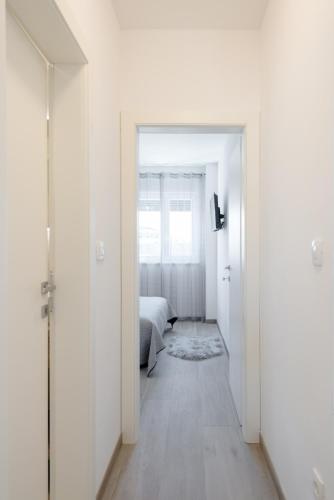 a bedroom with white walls and a bed and a hallway at La vie est belle in Trogir