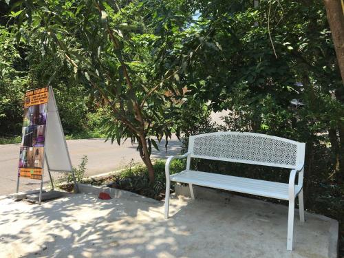 a white bench sitting in front of a tree at BeachBox@Koh Сhang in Ko Chang