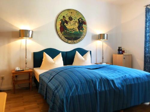 a bedroom with a blue bed with two lamps at Hotel Mariahilf München in Munich