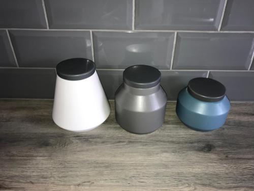 three containers sitting on a counter in a kitchen at Glens of Antrim Beach House - On the Coast in Glenariff