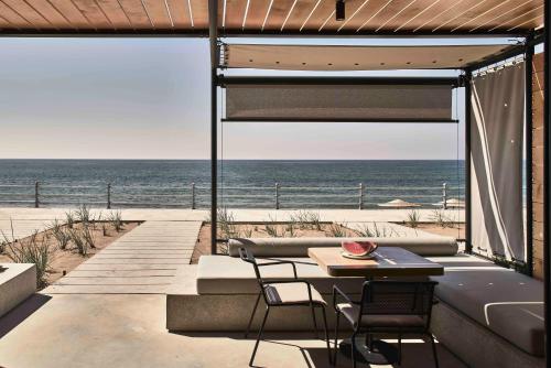 a patio with a table and chairs and the ocean at Dexamenes Seaside Hotel in Kourouta