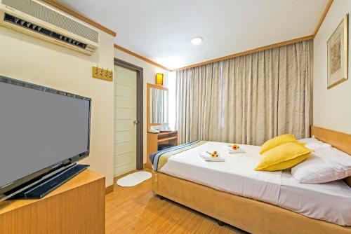 a bedroom with a bed and a flat screen tv at Hotel 81 Sakura in Singapore