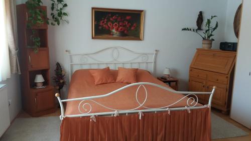 sypialnia z łóżkiem z pomarańczową kołdrą w obiekcie Magdi Apartman w Balatonfüred