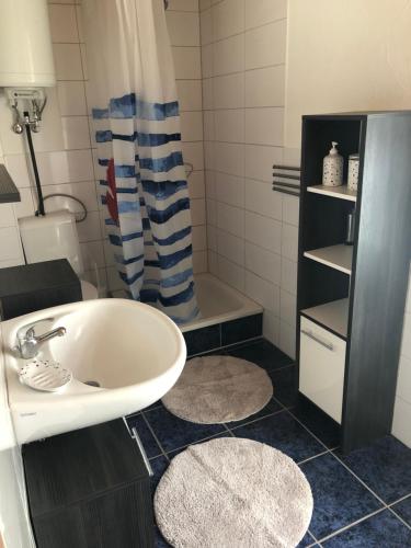 a bathroom with a white sink and a shower at Bungalow am Dobbertiner See in Dobbertin