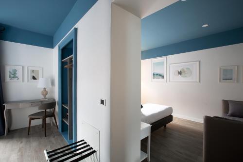 a bedroom with a bed and a desk in a room at Hotel Orso Bruno in Carate Urio