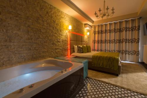 a bathroom with a tub and a bed in a room at Romantic Jacuzzi Belleview Studio in Sinaia