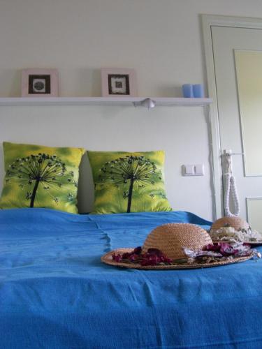 Una cama con sábanas azules y dos sombreros. en Bed and Garden Alde Coninckshof en Weurt