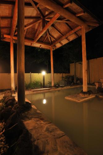 a pool of water with a pavilion at night at Yumoto Itaya in Nikko
