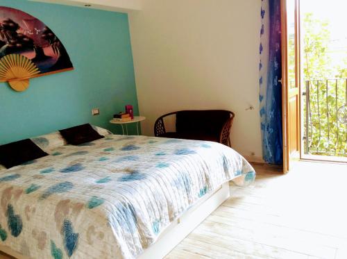 a bedroom with a bed and a chair and a window at La Perla del Sud in Teulada