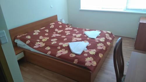 ein kleines Bett mit lila Bettwäsche und Blumen darauf in der Unterkunft Wellness Home Apartment in Beli Iskar