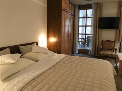 a bedroom with a large white bed and a window at Apartmaji Sušnik in Bled
