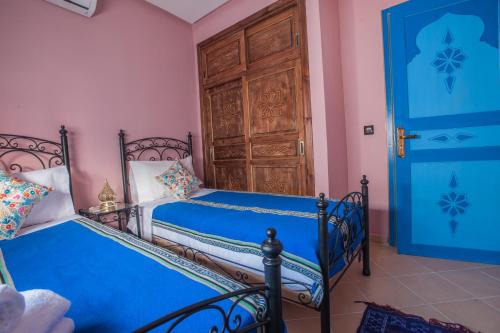 a bedroom with two beds and a door at Puerta Azul in Chefchaouene