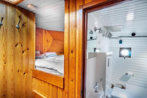 Una pequeña habitación con una cama y un baño. en Asile Flottant, en Ámsterdam