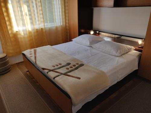 sypialnia z łóżkiem z białą pościelą i poduszkami w obiekcie Apartment Zorić Grebaštica w mieście Grebaštica