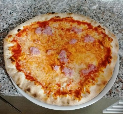 コステルマーノにあるAffittacamere Battistoliの皿に座ったピザ