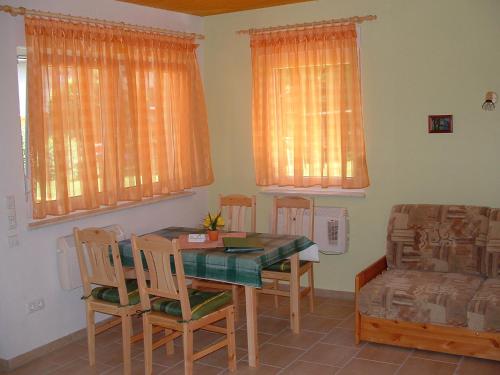 a dining room with a table and chairs and a couch at Ferienhof Zum Kammergut- Ferienhaus- Ferienwohnung in Zeulenroda