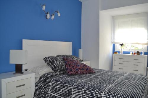 a bedroom with a bed with a blue wall at Torrenostra PLATJA in Torrenostra