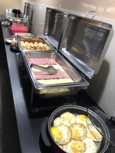 a stove with several trays of food on it at Hotel Mapuera in Oriximiná