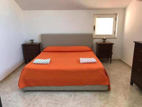 una camera da letto con un letto arancione con due cuscini sopra di Maison de Charme Iommella a Sant'Agnello