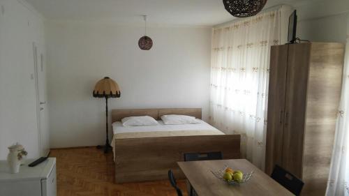 sypialnia z łóżkiem i stołem z misą owoców w obiekcie Apartments Struga w mieście Struga