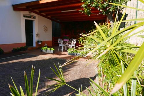 a patio with two white chairs and a table at B&B Ai Tre Archi in Spotorno