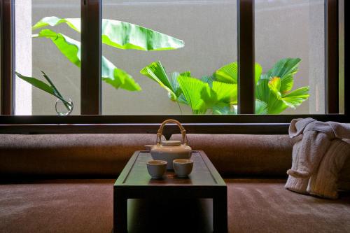 a table with two cups on it in front of a window at Narada Resort & Spa Perfume Bay Sanya - All Villas in Lingshui