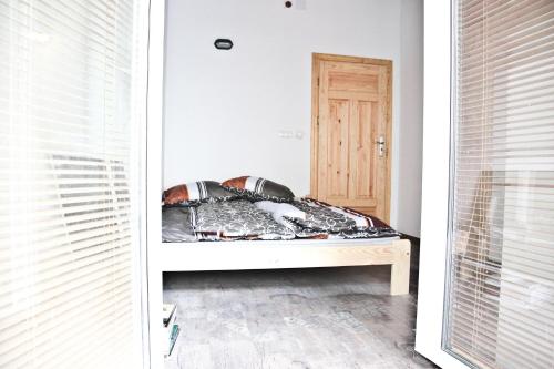 a bed in a room with a window and a door at Szmulson in Warsaw