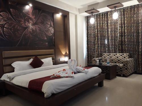 a bedroom with a bed with a large painting on the wall at Namaskar Residency in Amritsar